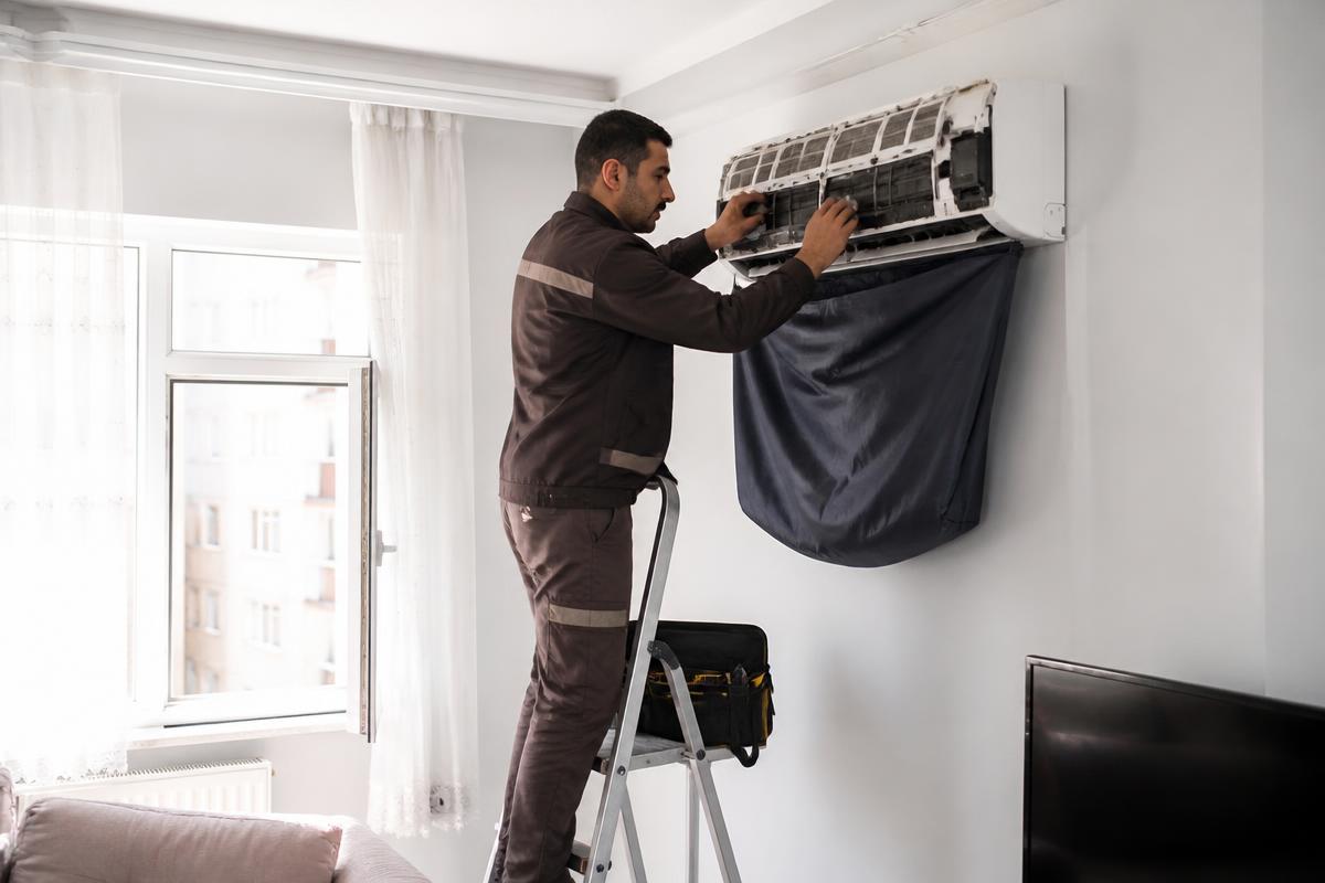 Teknisyenin duvar tipi klimanın bakımını yapması